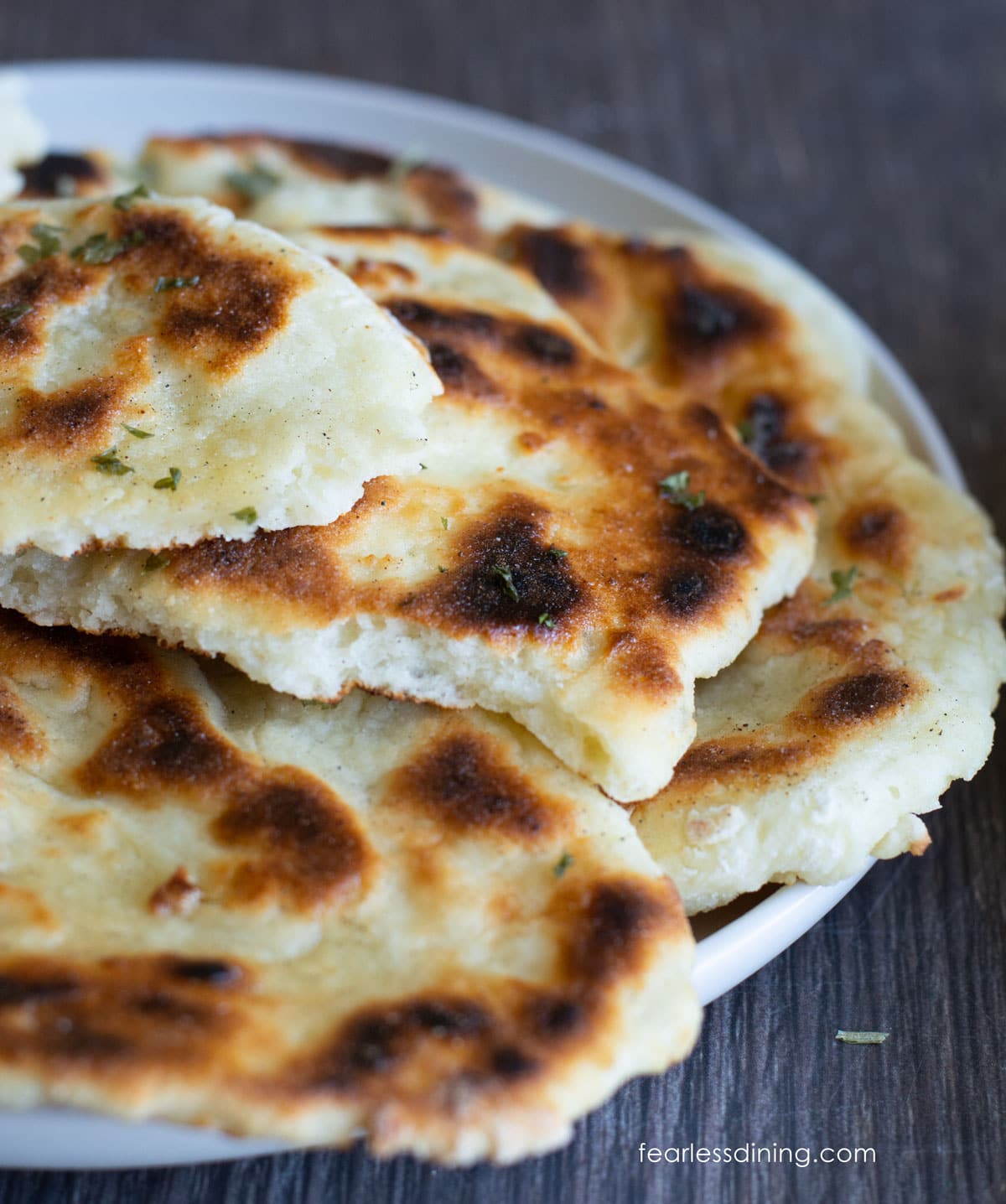 A piece of naan ripped in half so you can see the fluffy interior.