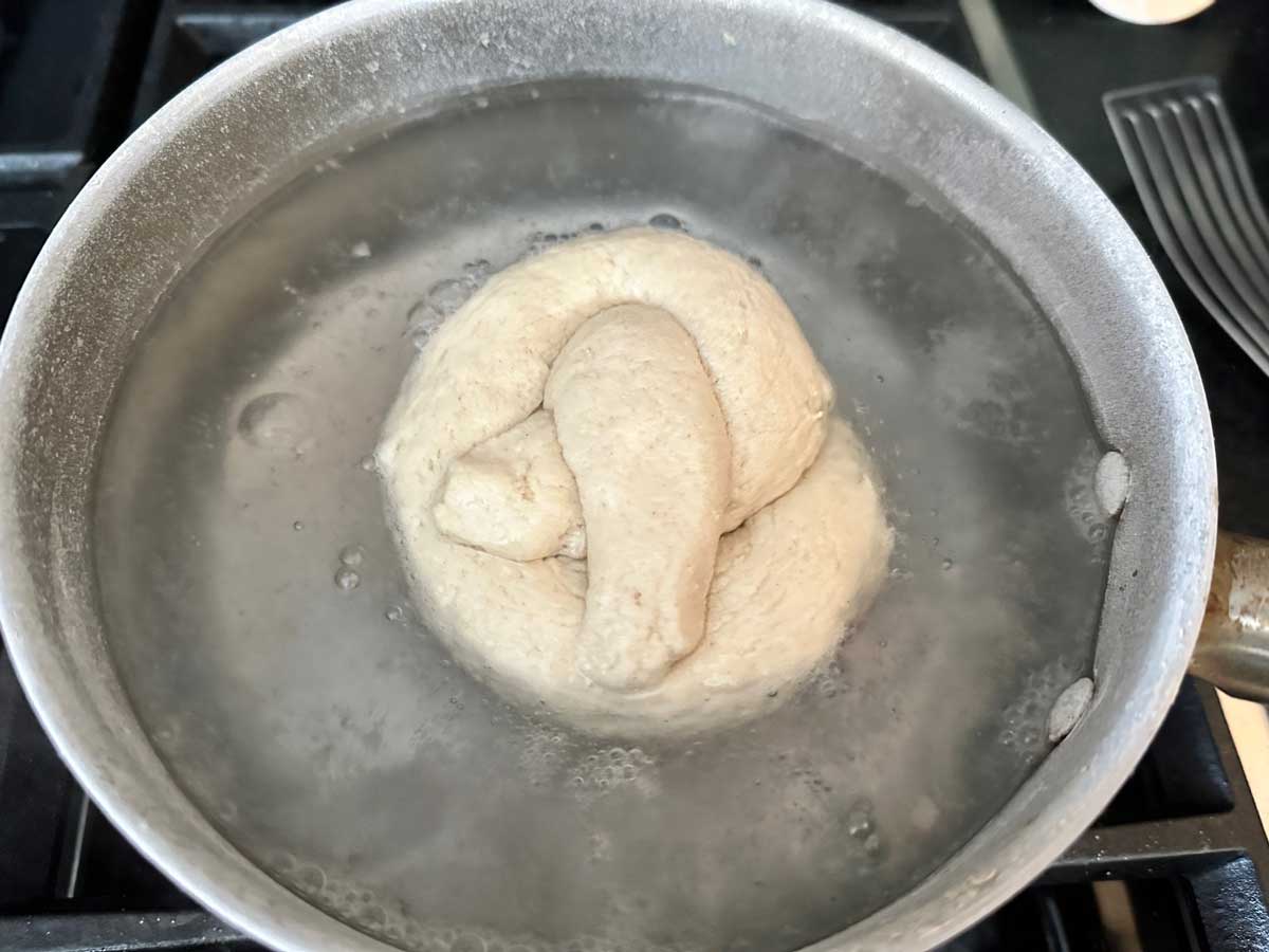 Pretzel dough boiling in baking soda water.