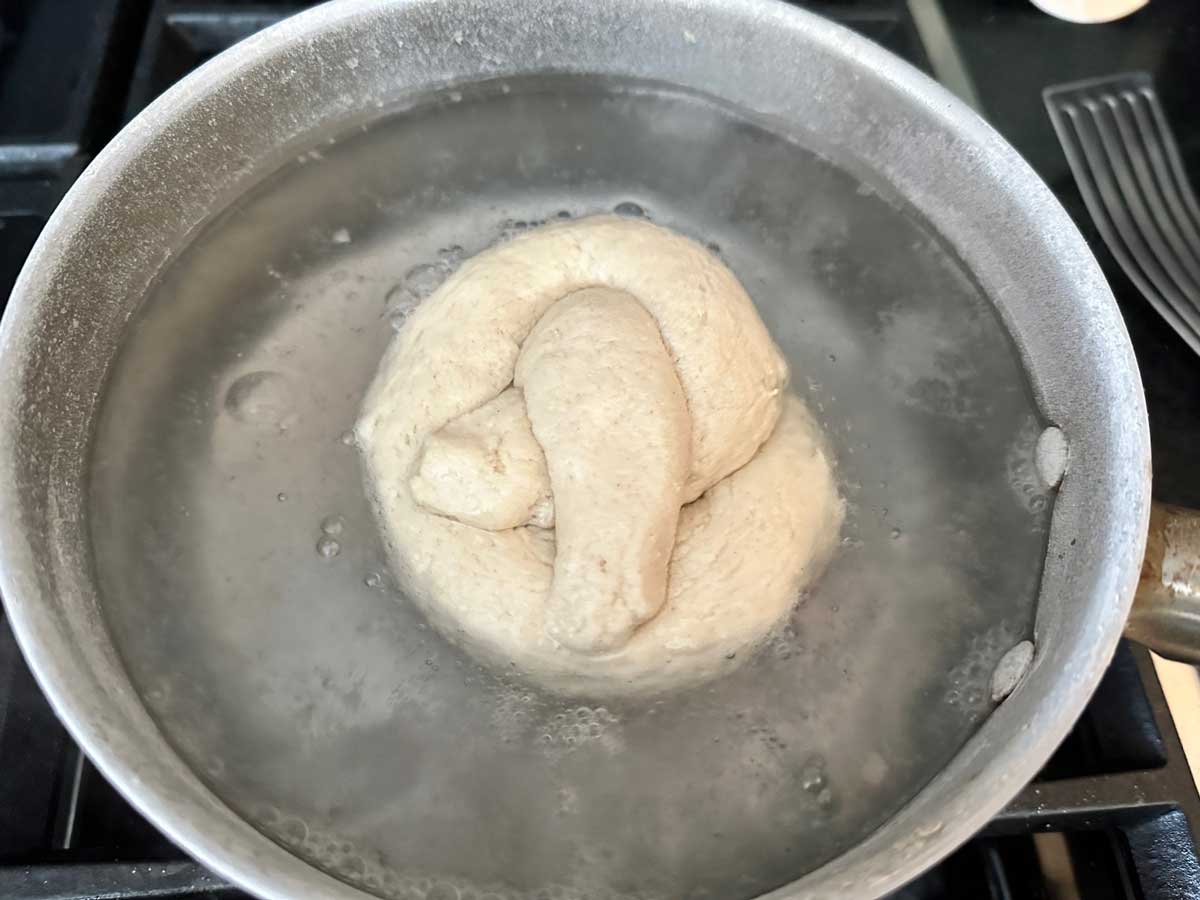 Pretzel dough boiling in baking soda water.