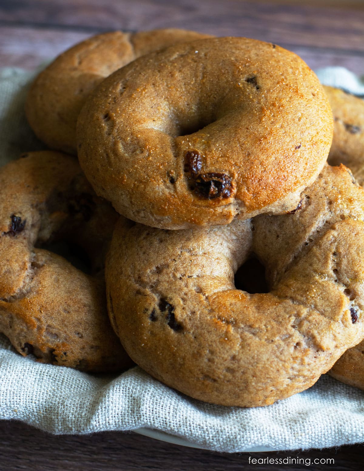 A basket filled with gluten free cinnamon raisin bagels.