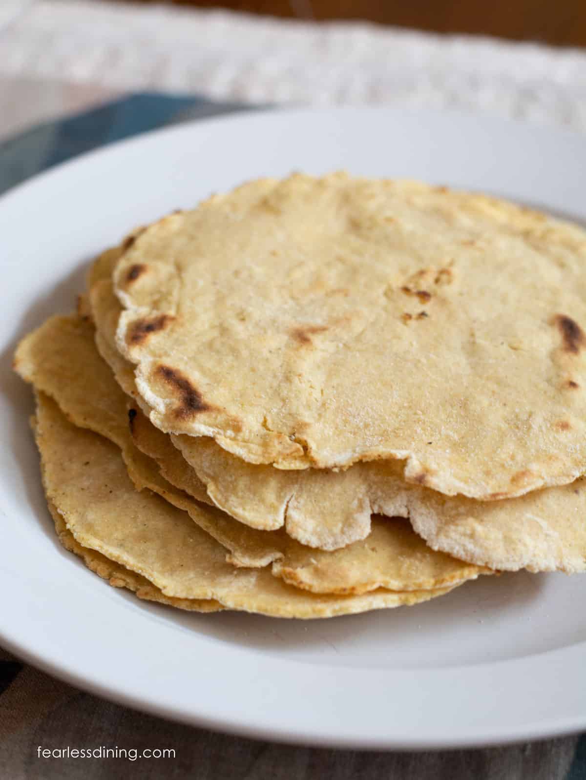 A stack of warm corn tortillas on a plate.