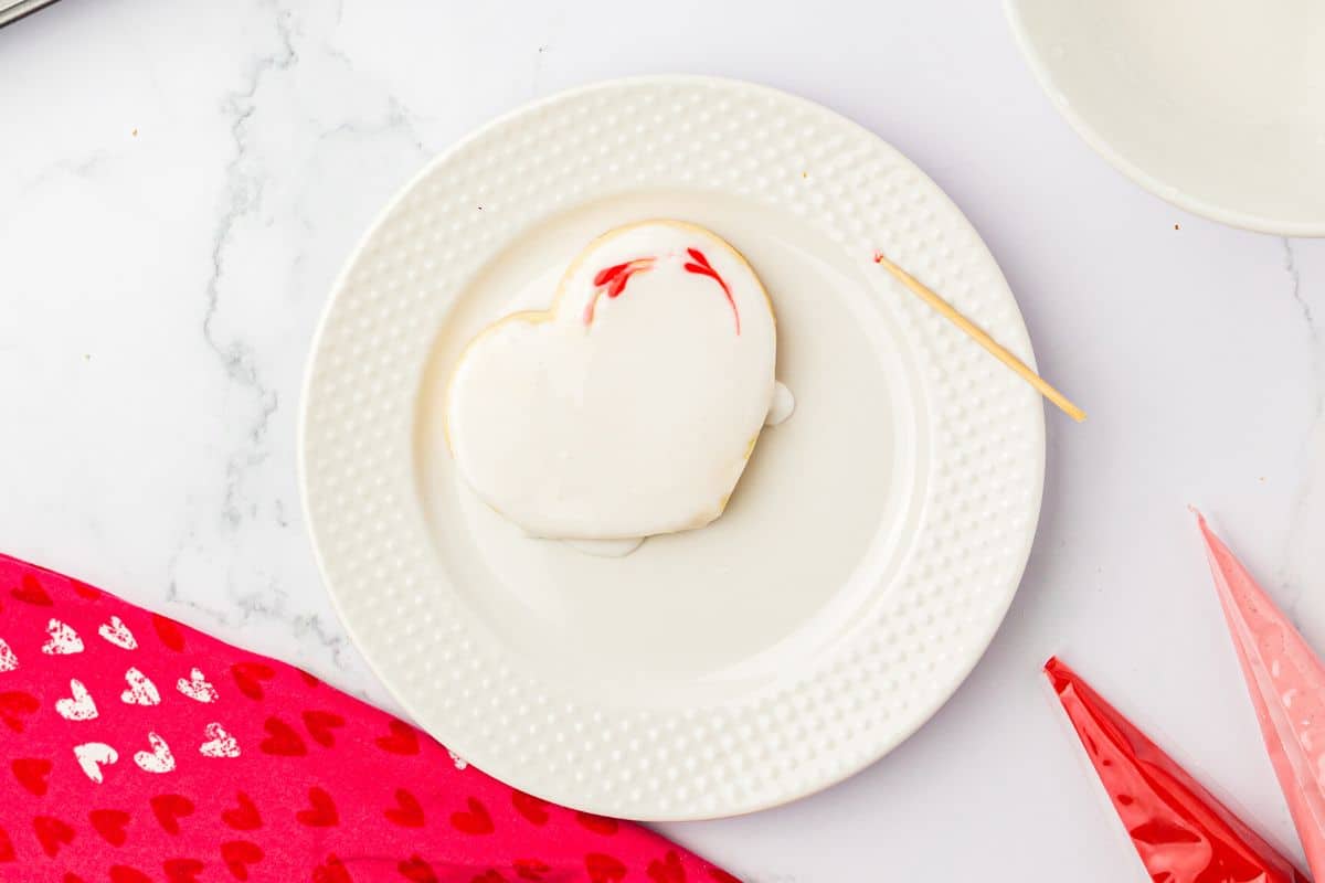 Icing dots after a toothpick was dragged through them. It left heart shapes of icing.