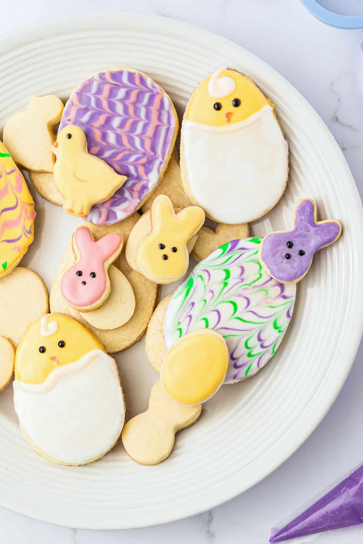 A plate full of gluten free Easter cookies on a white plate.