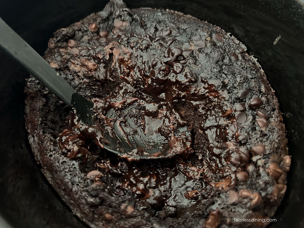 A black serving spoon in the lava cake.