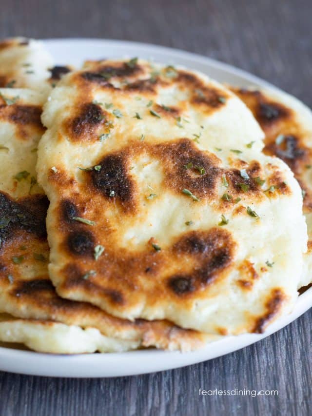 A photo of several pieces of gluten free naan on a white plate.