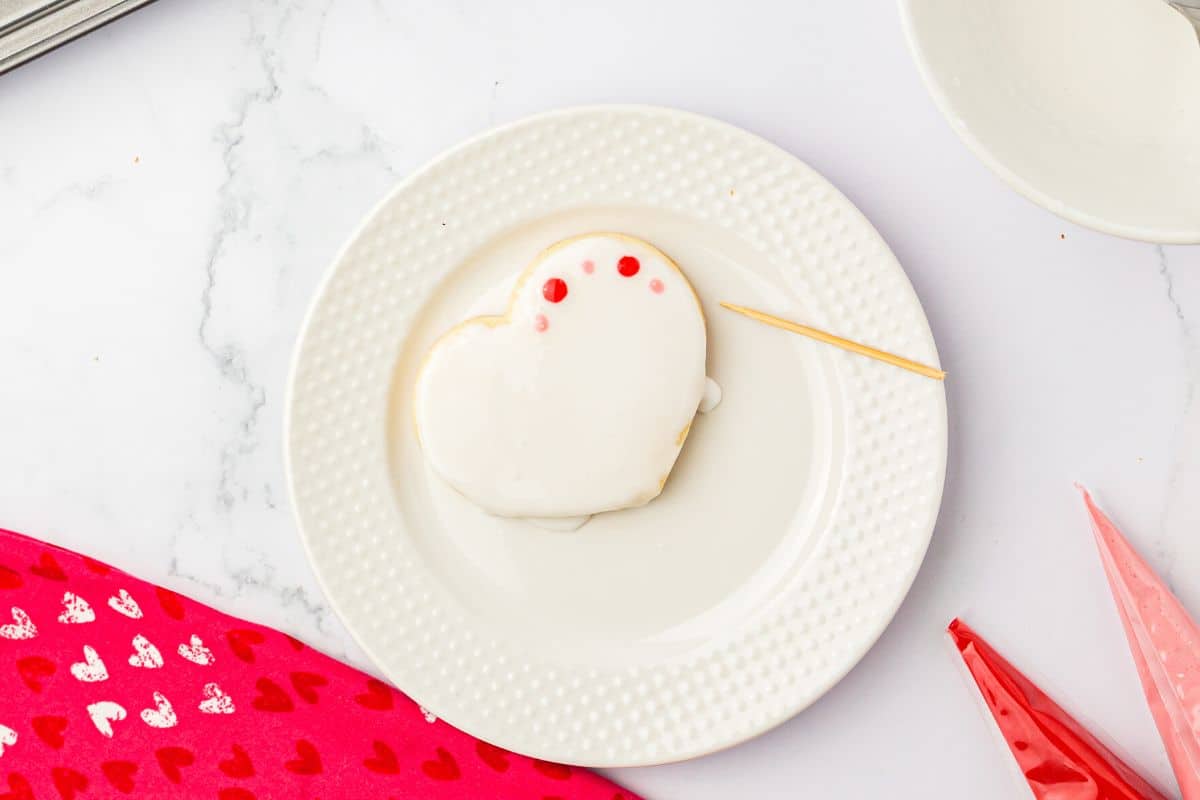 Making colorful royal icing dots on the cookie.