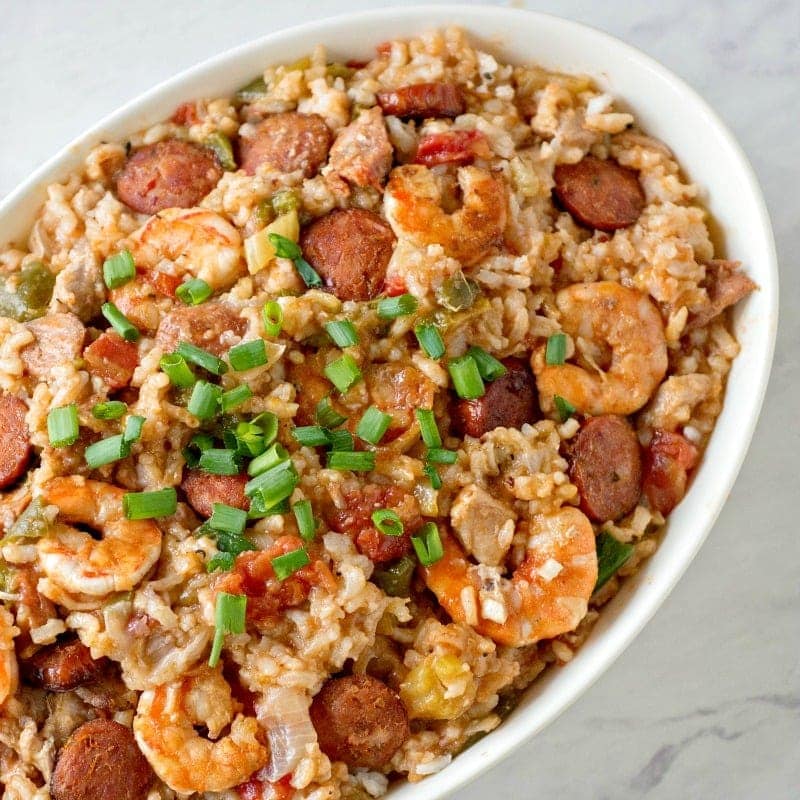 An oval shaped serving dish filled with jambalaya.