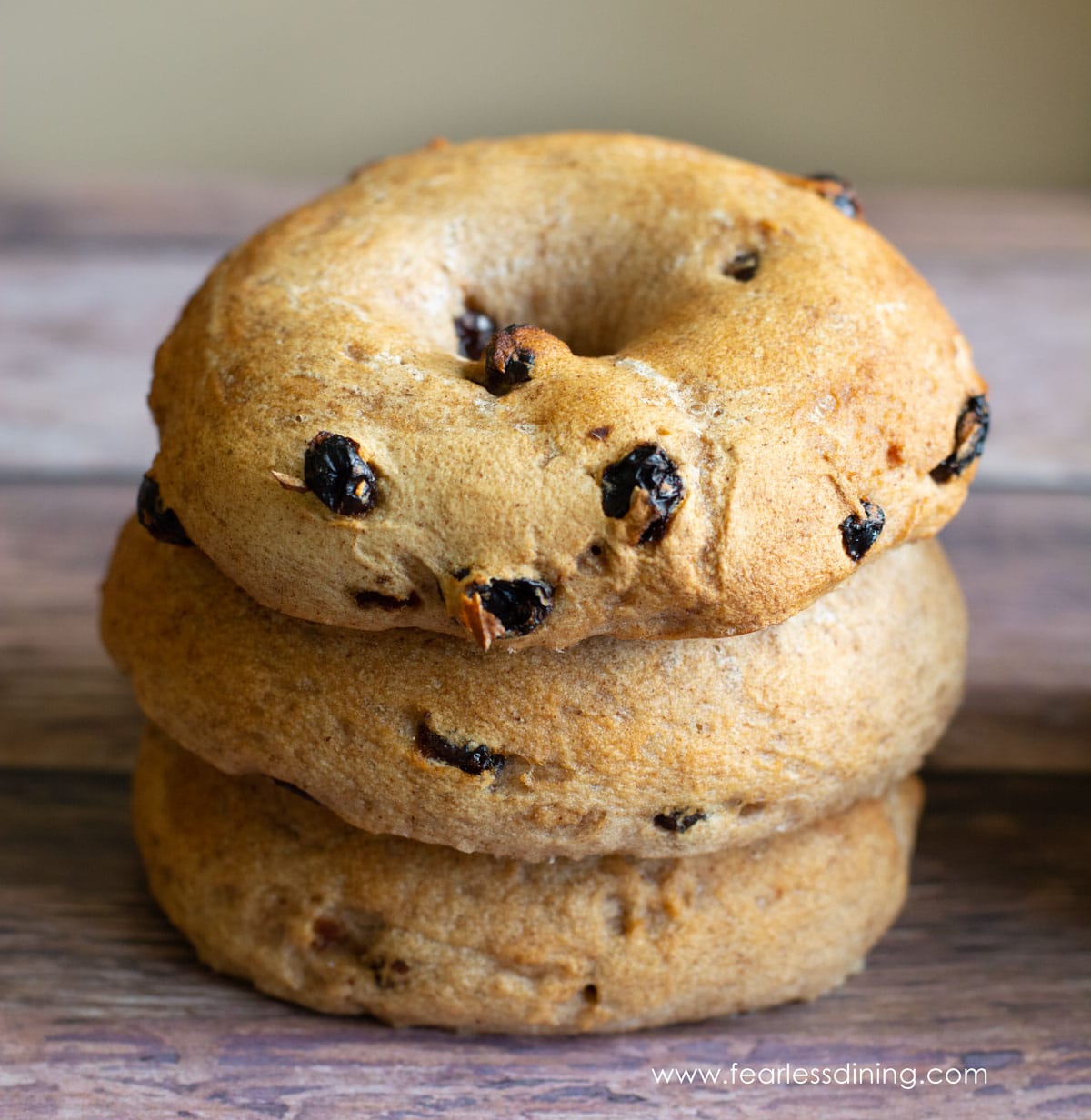 A stack of three gluten free cinnamon raisin bagels made with Steve's gluten free bread flour blend.