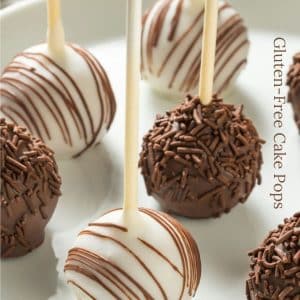 Vanilla and chocolate decorated cake pops on a white plate.
