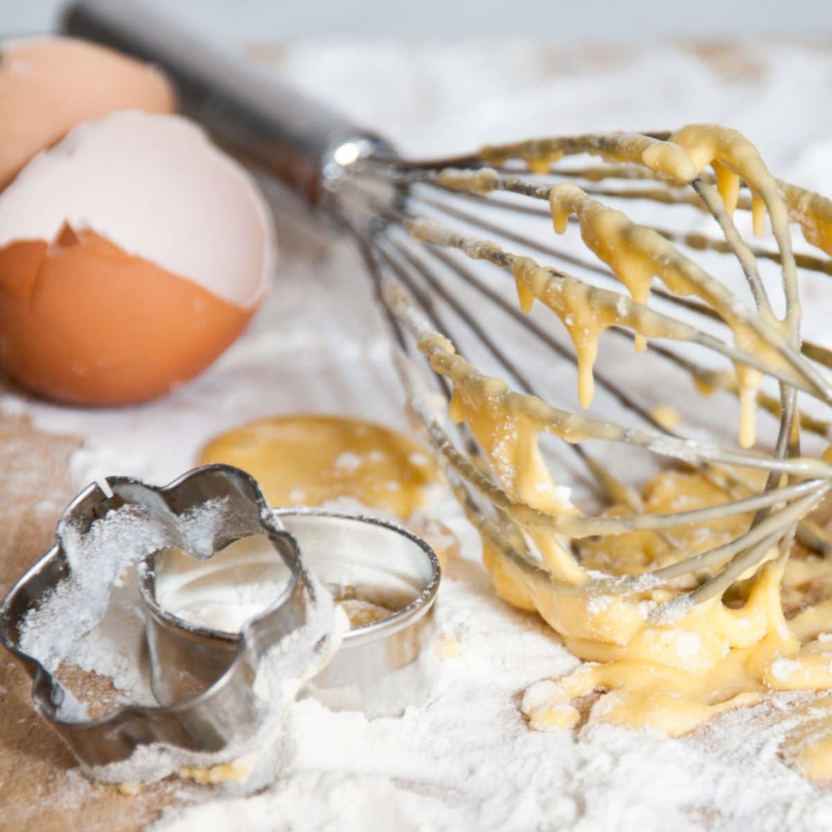 A whisk and other cookie making tools on the counter.