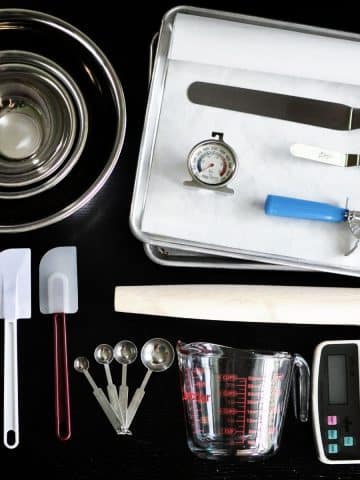 Some kitchen baking tools on a black granite counter.