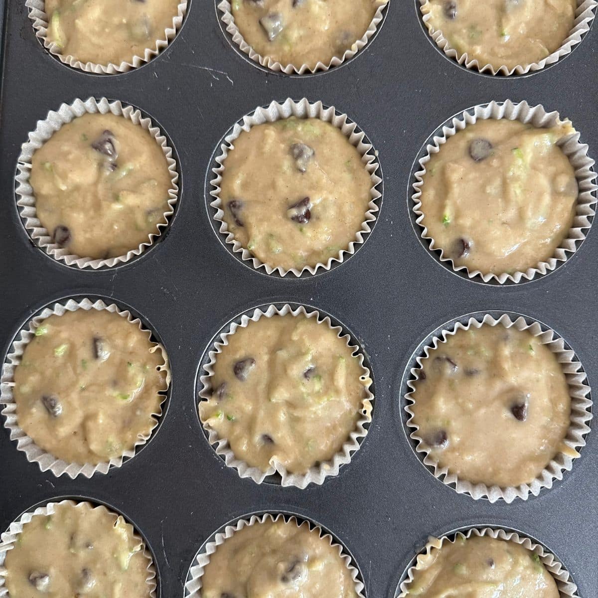 Muffin batter in a muffin pan, ready to bake.