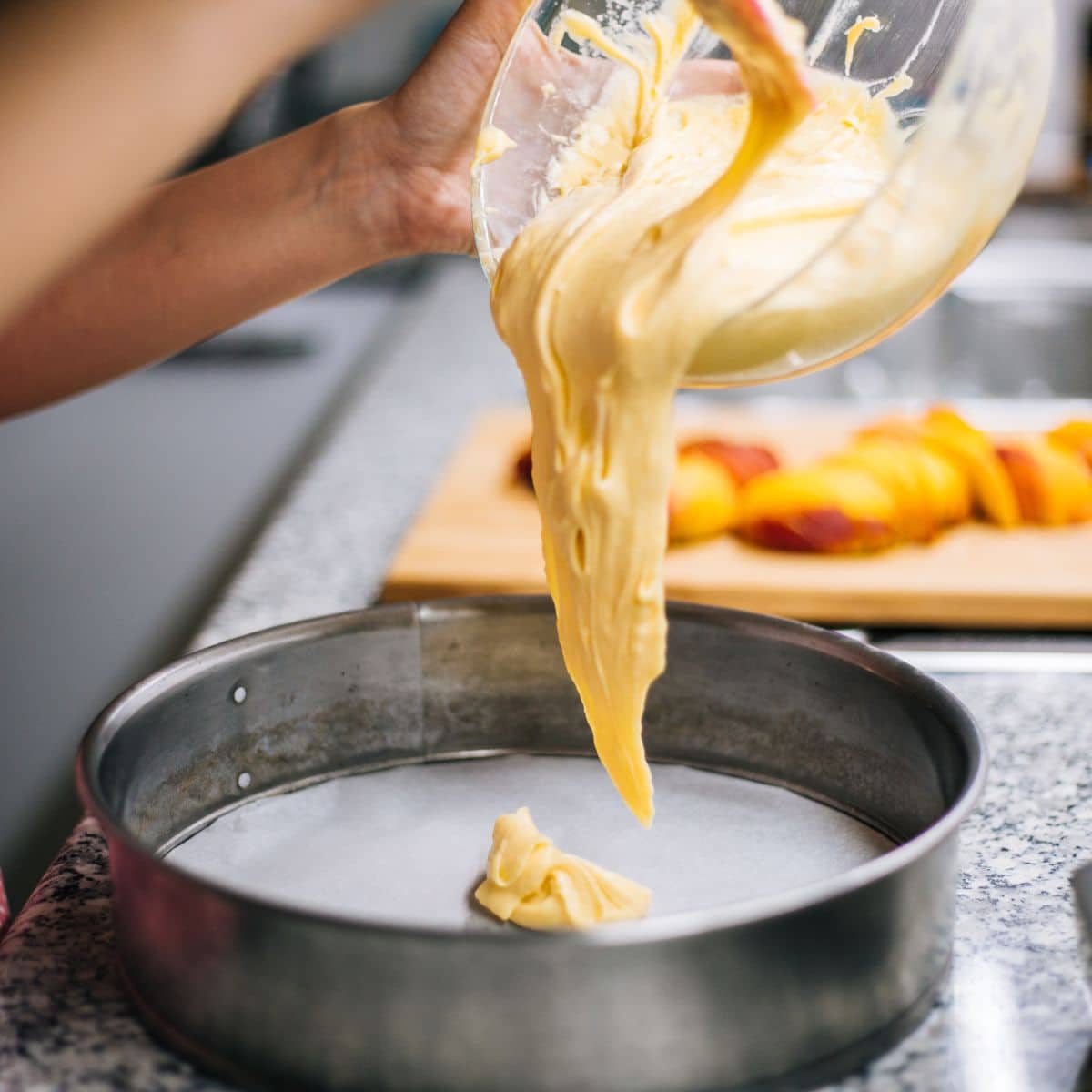 Pouring cake batter into a springform pan.