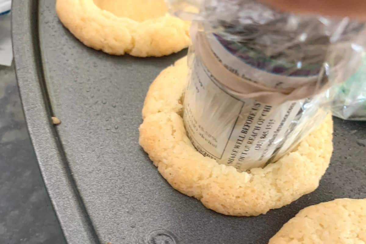 Using a small jar to press the middle down in each cookie section.