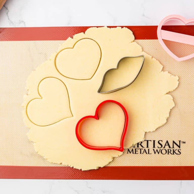 Cookie cutters pressed into cookie dough.