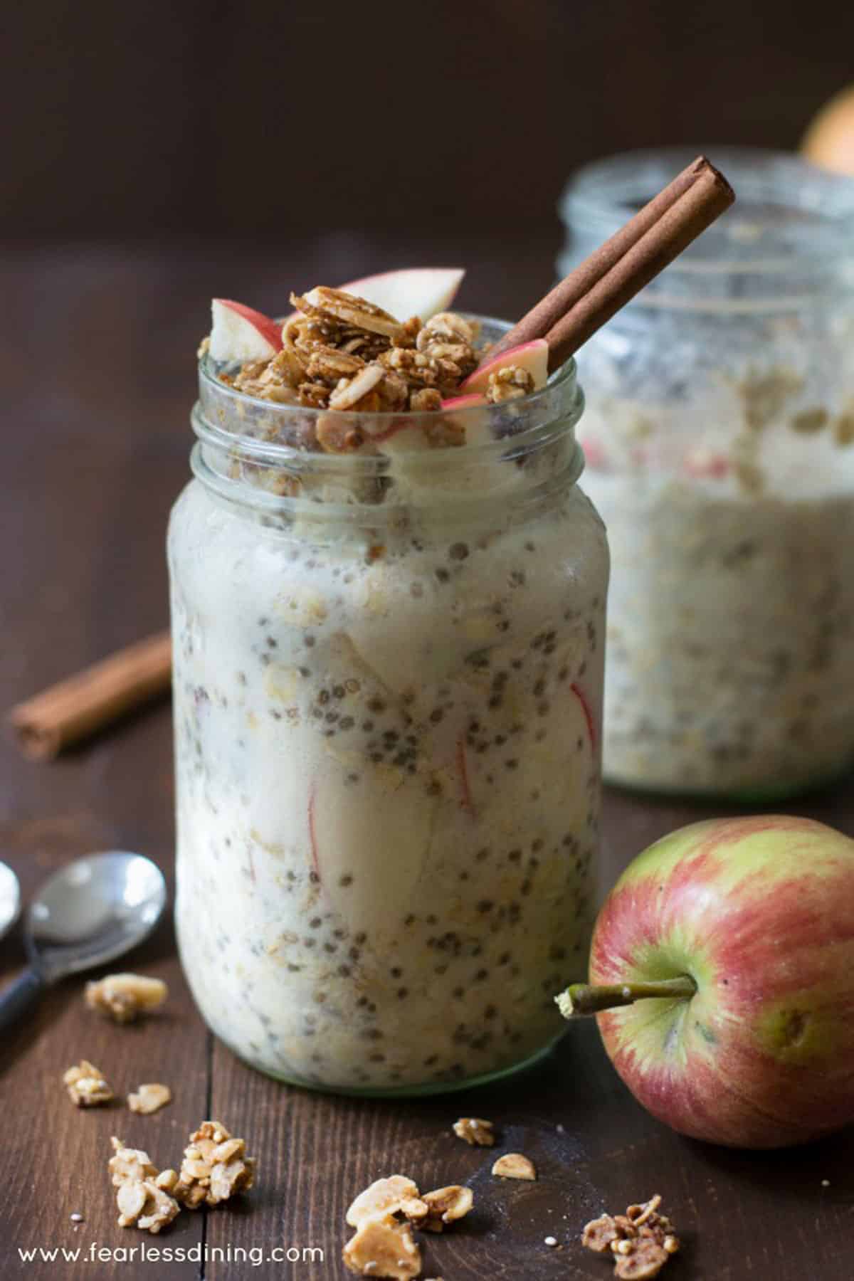 Gluten free overnight oats in two mason jars. The oats are topped with apple granola.