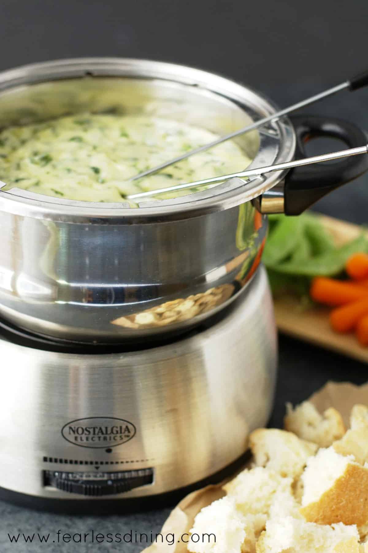 A fondue pot full of melty cheese.