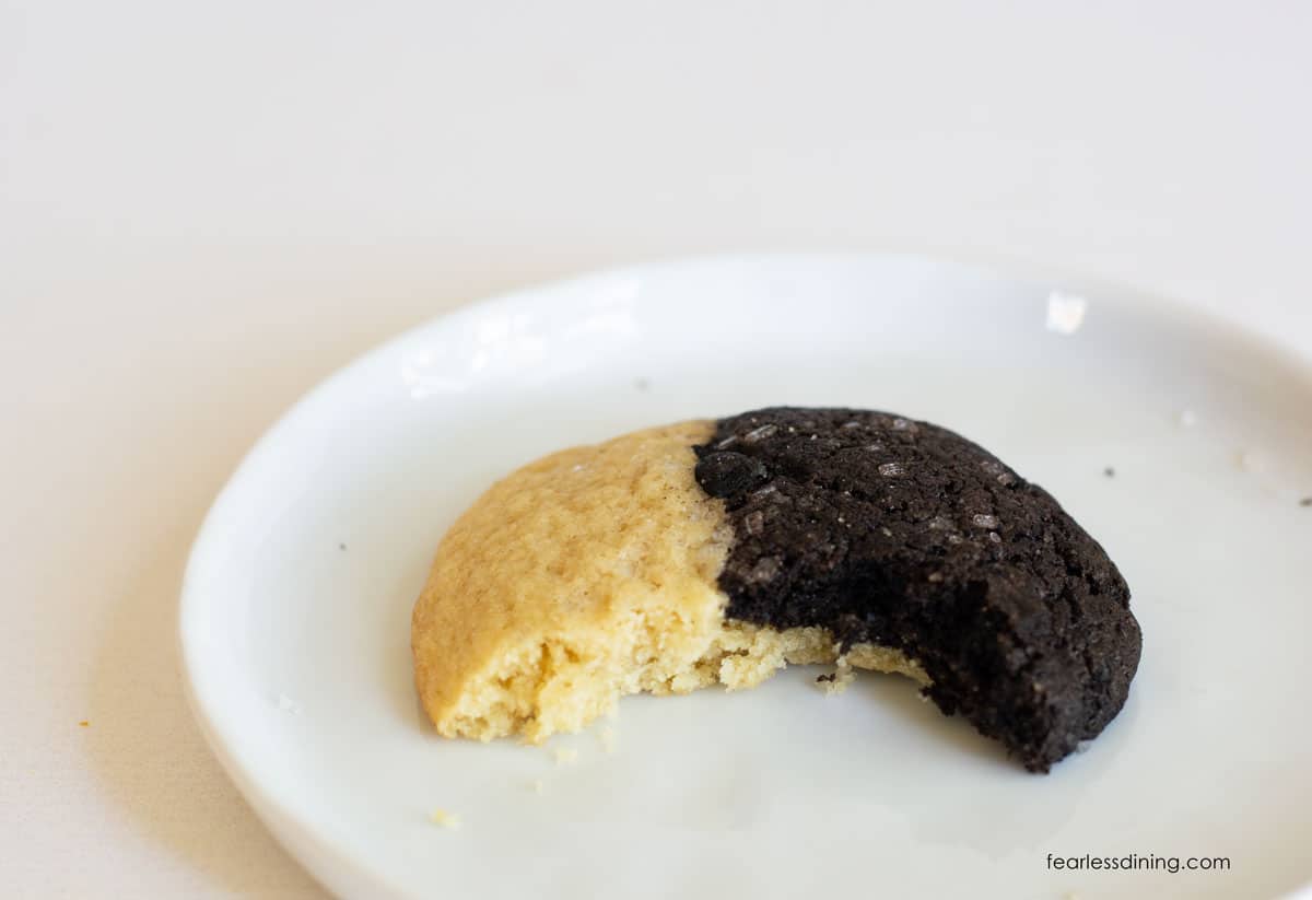 A gluten free chocolate vanilla cookie with a bite taken out.