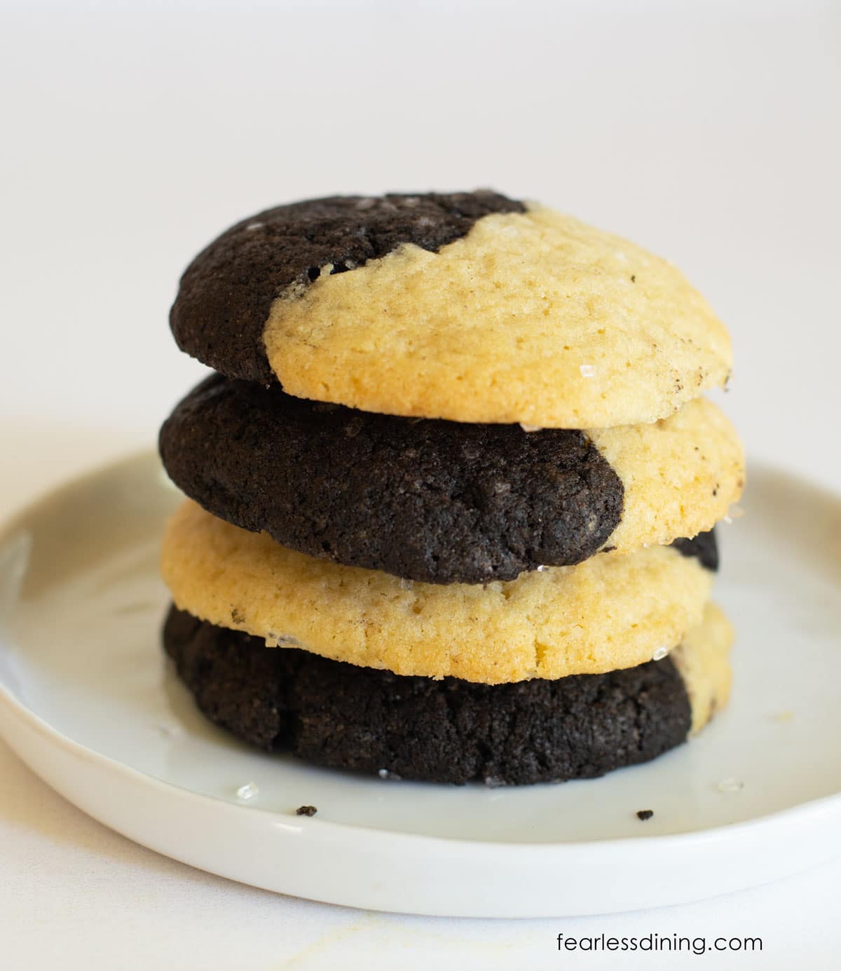 A stack of four gluten free chocolate and vanilla cookies.