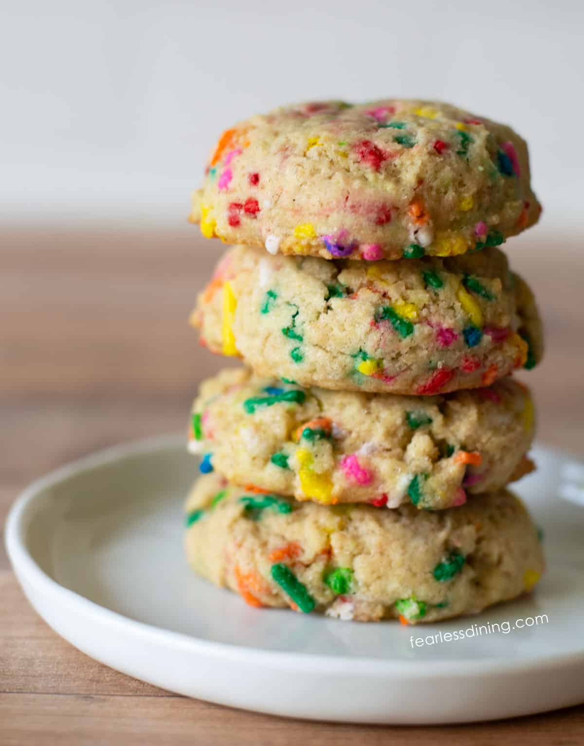 A stack of four gluten-free funfetti cookies on a plate.