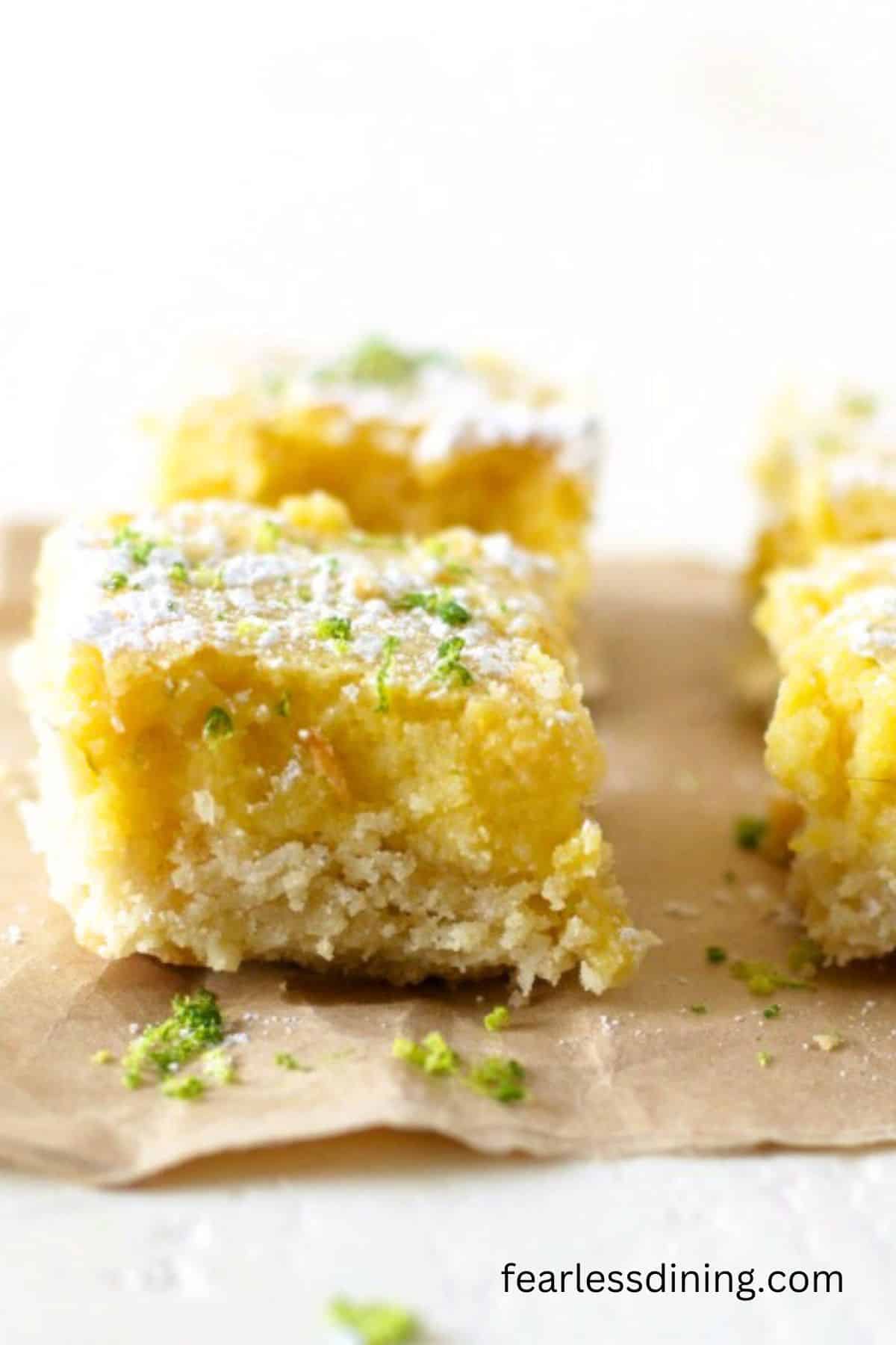 Gluten free lime cookie bars on a brown paper bag.