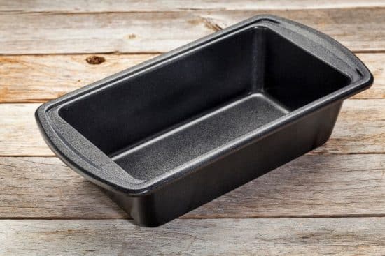 An empty loaf pan on a wooden table.
