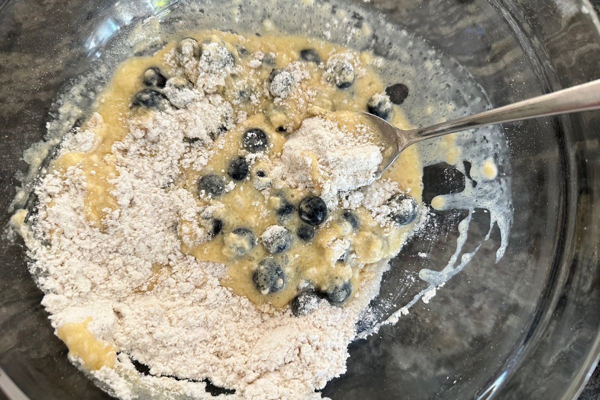 A bowl with the wet and dry ingredients getting mixed together.