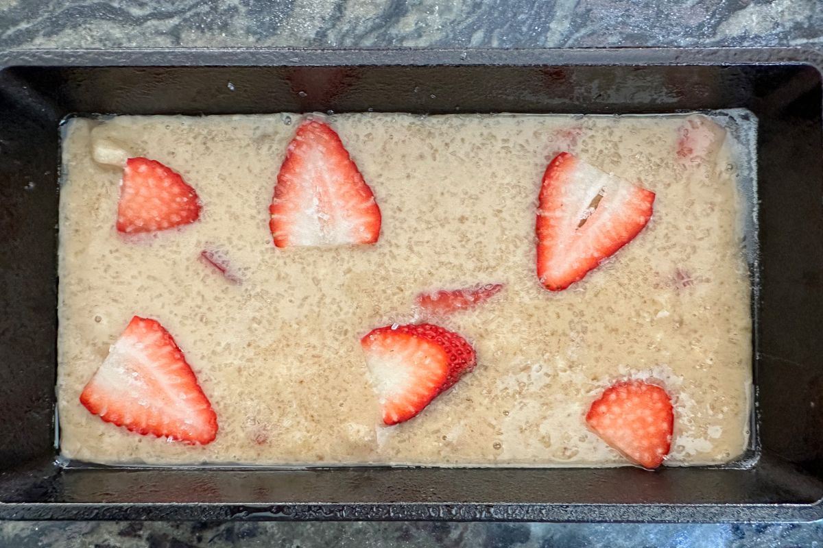 The strawberry banana bread batter in a loaf pan, ready to bake.