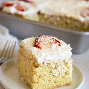 A slice of gluten free tres leches cake on a small white plate.