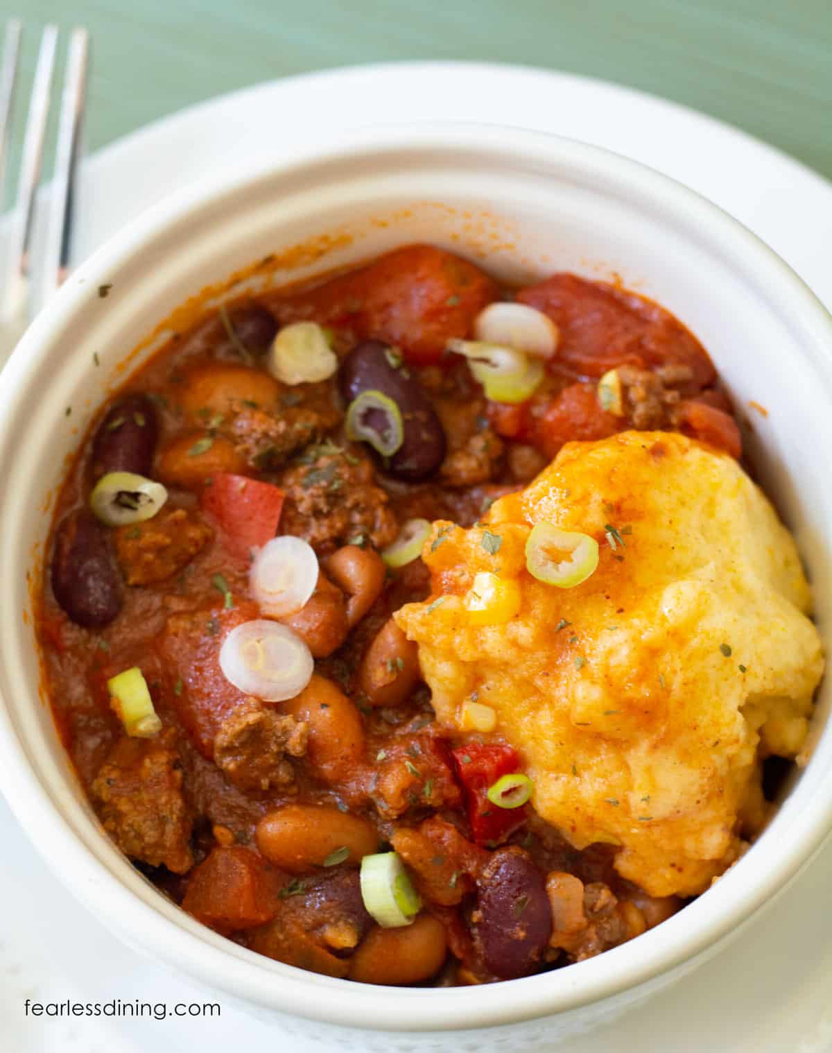 The top view of a gluten free corn dumpling in a bowl of chili.