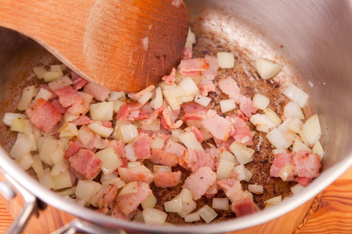 Onion and bacon cooking in a pot.
