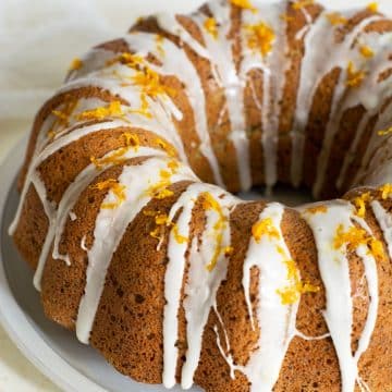 A photo of the orange bundt cake topped with icing and orange zest.