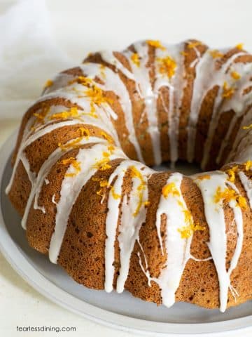 A photo of the orange bundt cake topped with icing and orange zest.