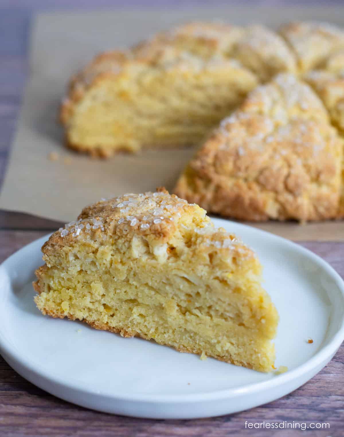 An orange scone on a white plate.