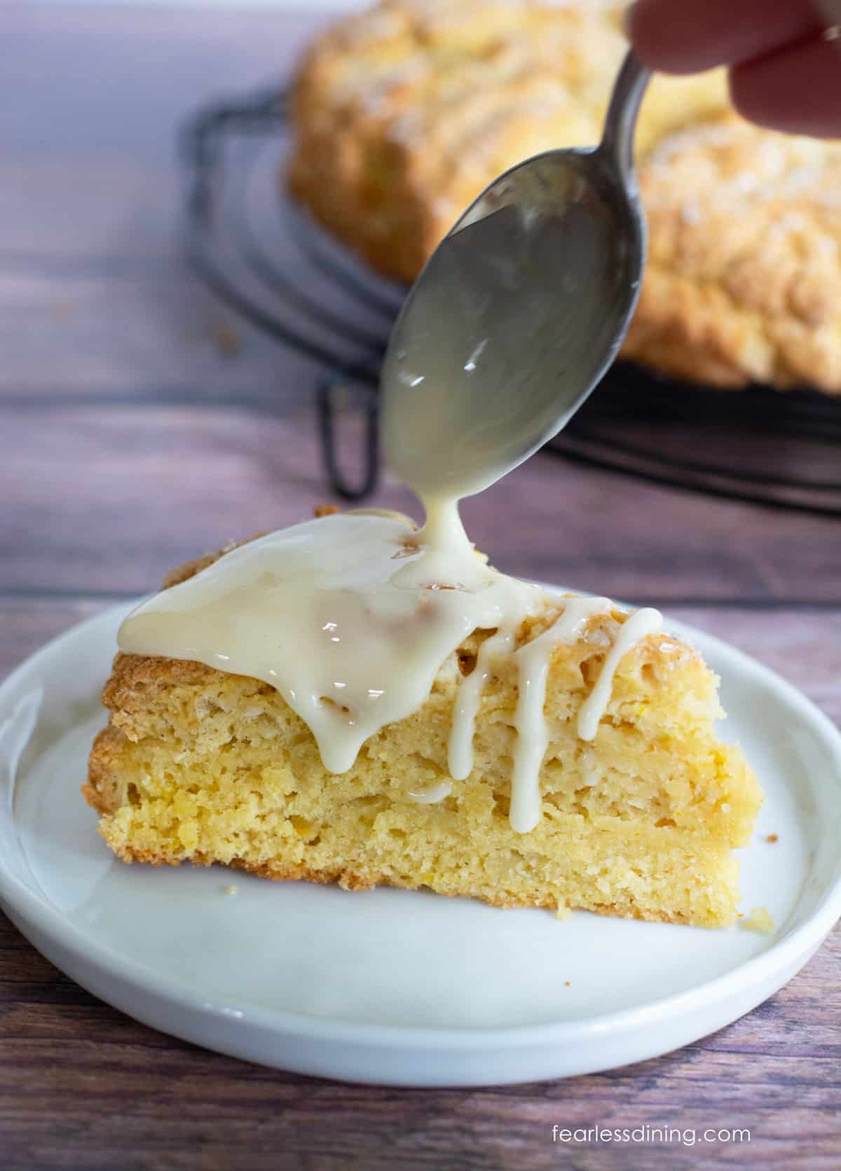 A photo showing me drizzle the icing over a scone.