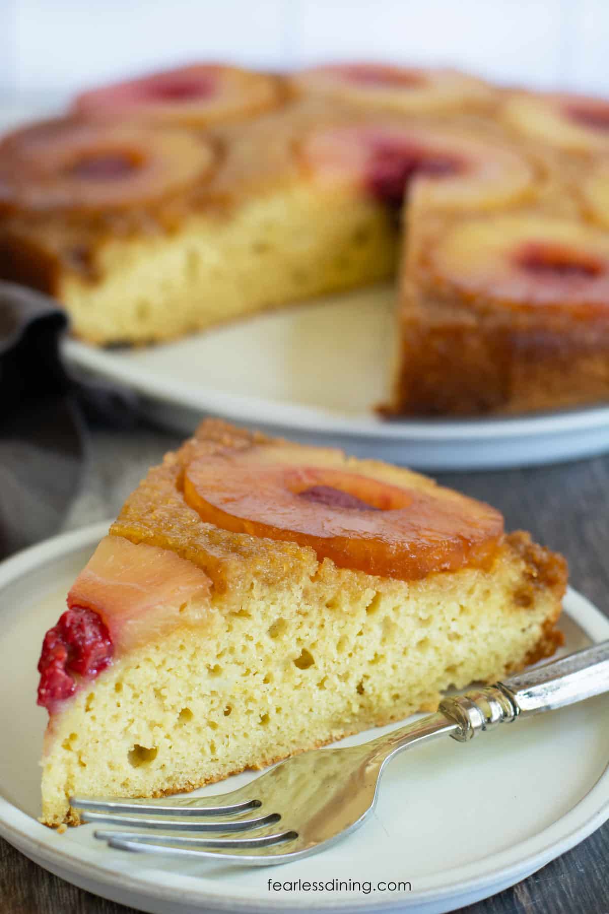 A slice of gluten free pineapple upside down cake on a plate.