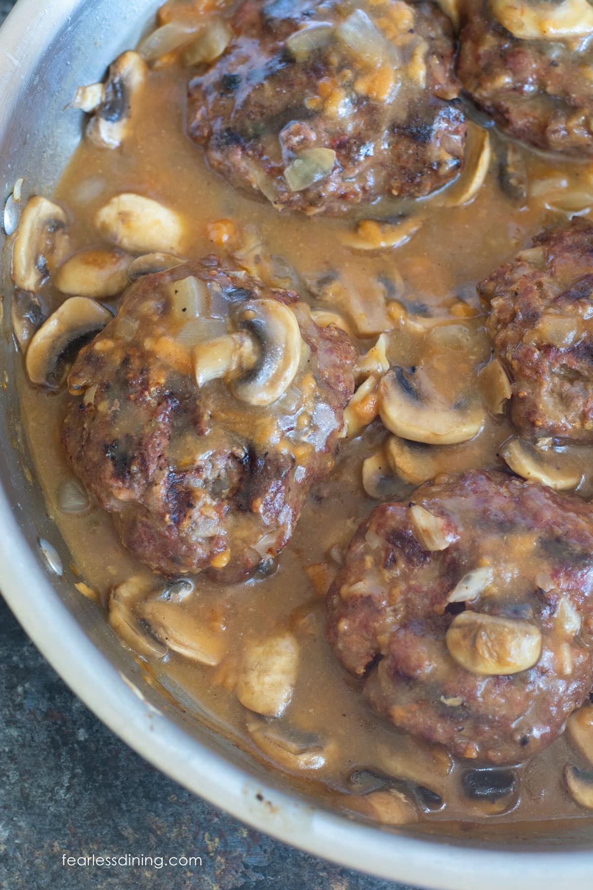 A large pan filled with cooked Salisbury Steaks.