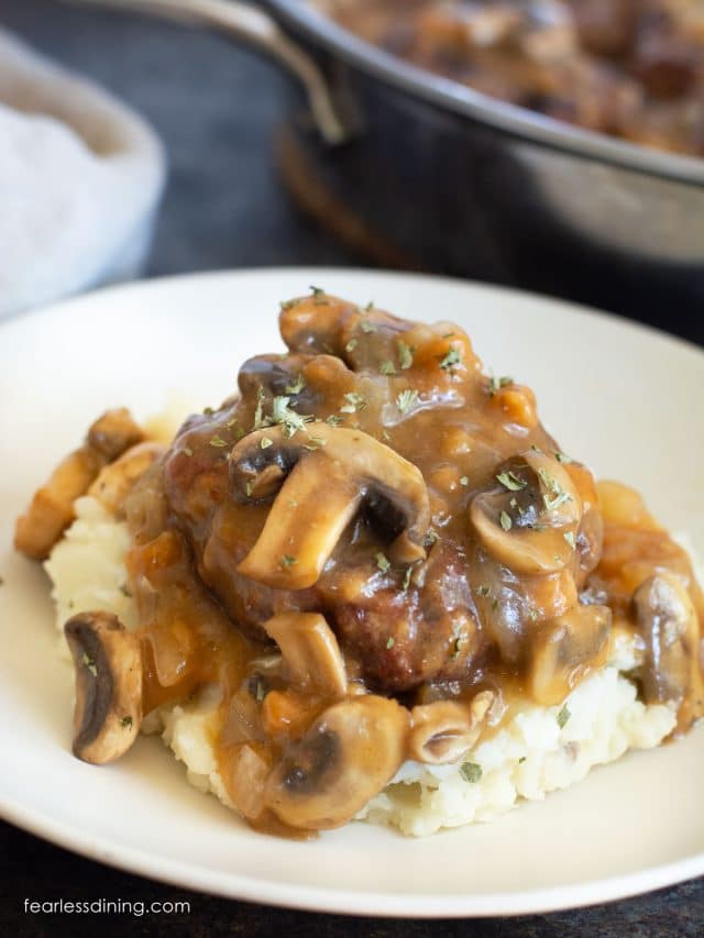 A salisbury steak topped with mushroom gravy on top of mashed potatoes.