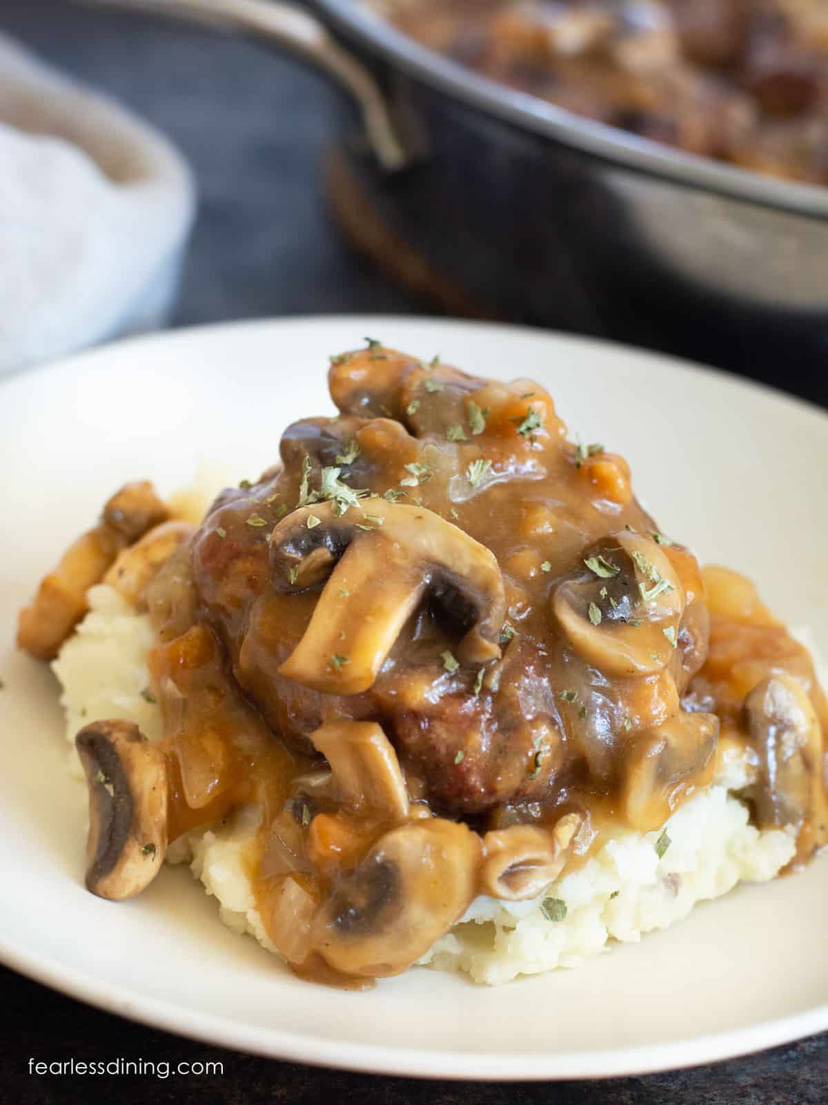 A salisbury steak topped with mushroom gravy on top of mashed potatoes.