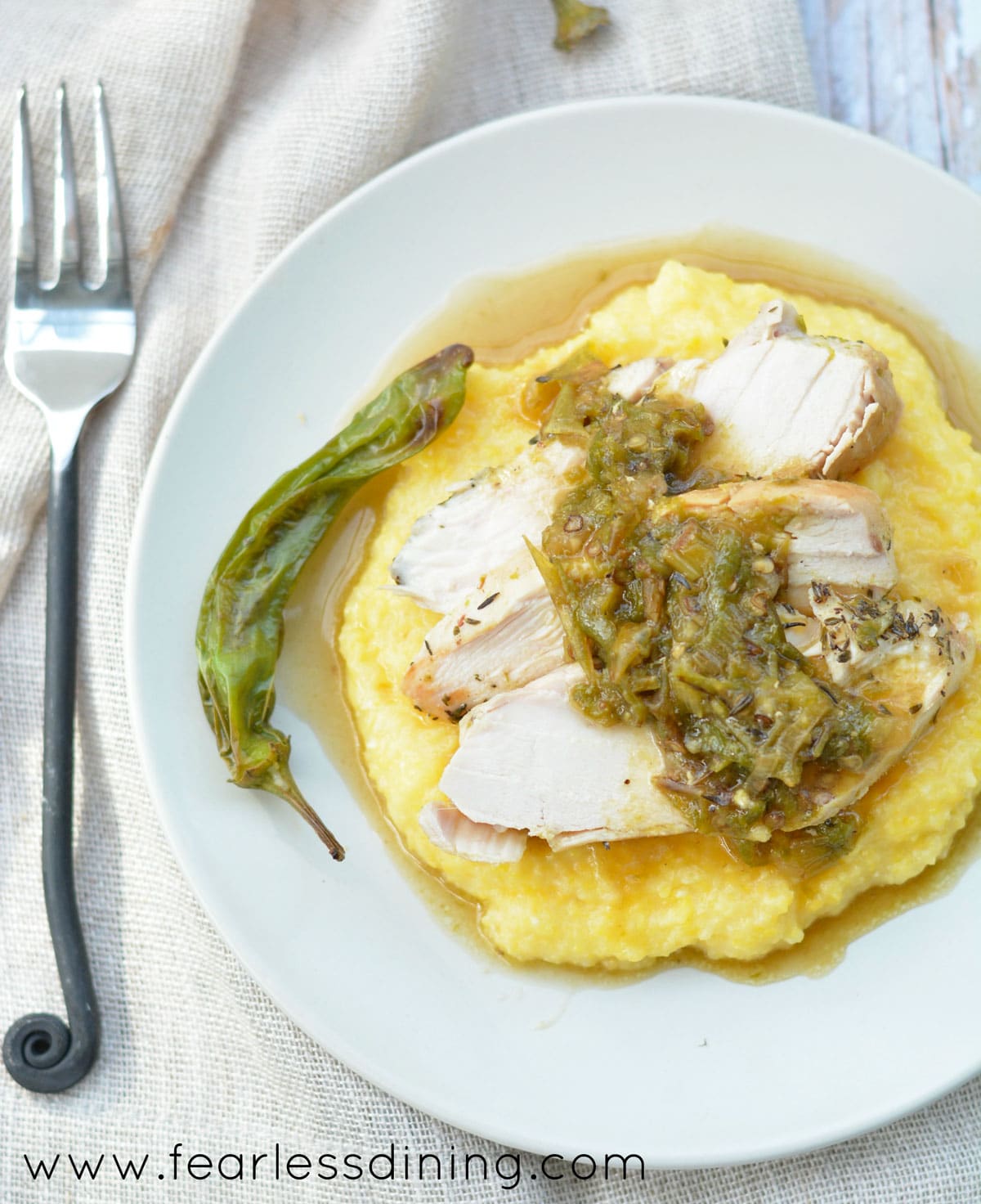 The top view of the chicken on top of the polenta with shishito pepper sauce.