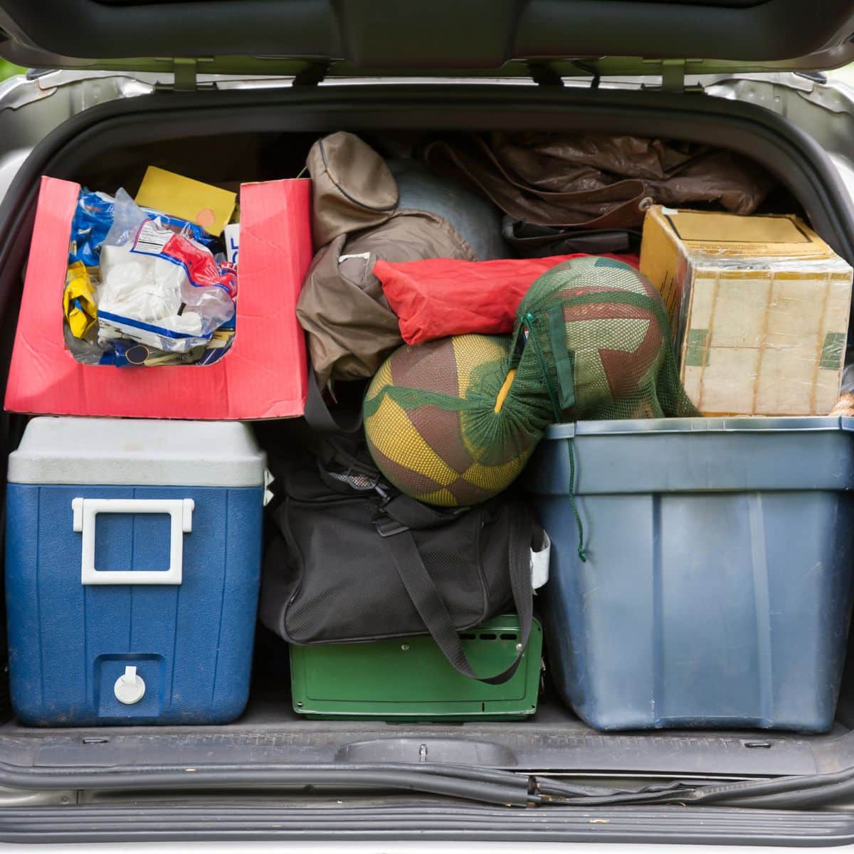 The back of an SUV filled with camping supplies and coolers.