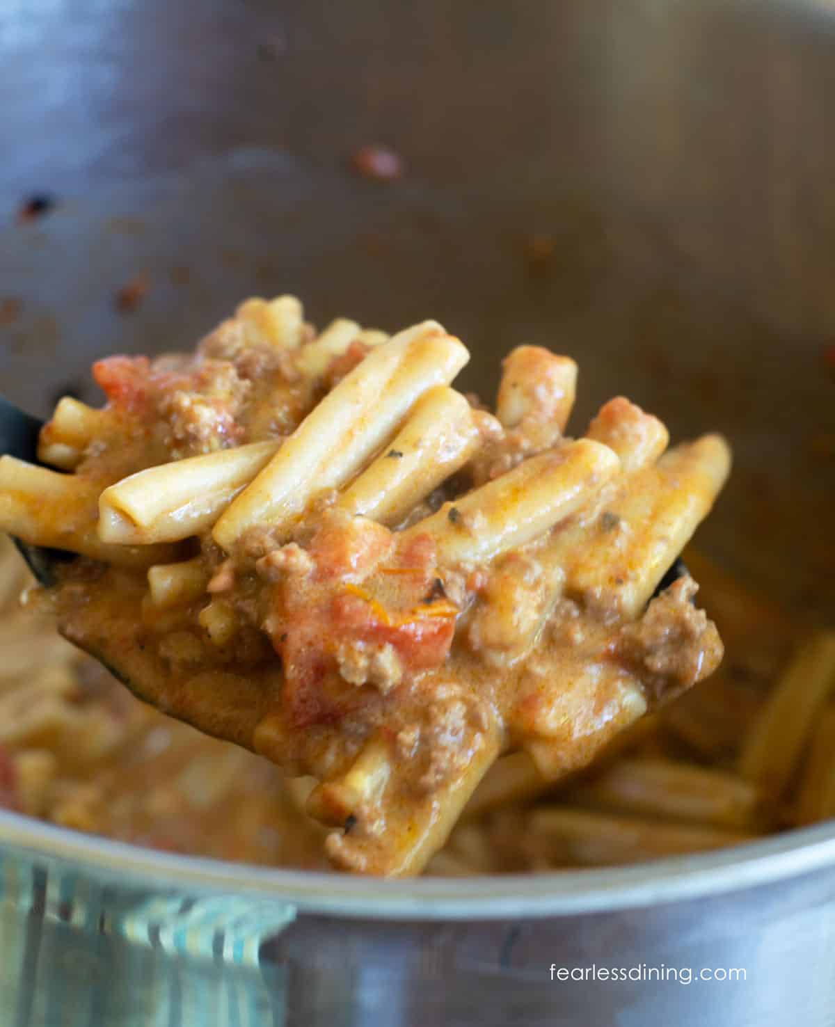 A serving spoon full of cheeseburger pasta.