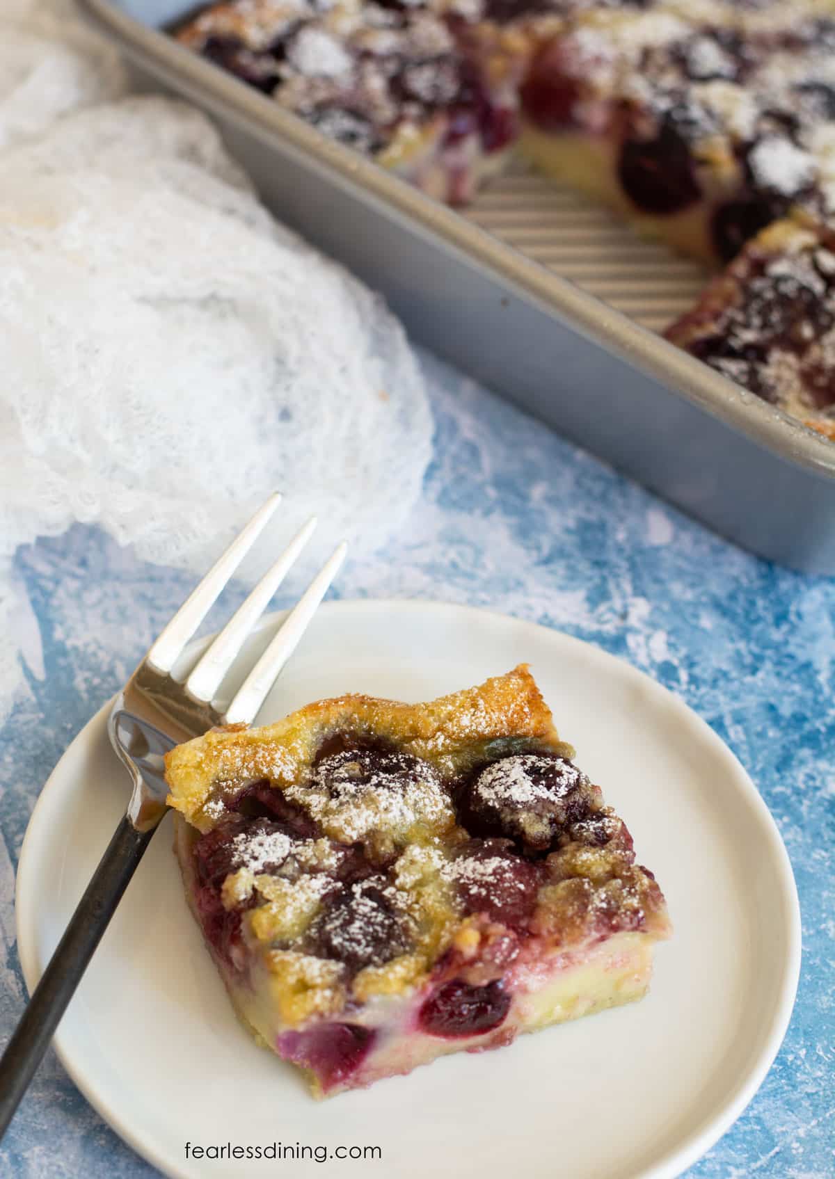 A slice of gluten free cherry clafoutis on a plate.