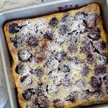 A baked gluten free cherry clafoutis in an 8x8 baking pan.