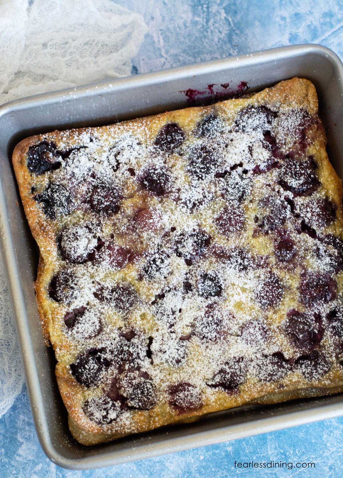 A baked gluten free cherry clafoutis in an 8x8 baking pan.