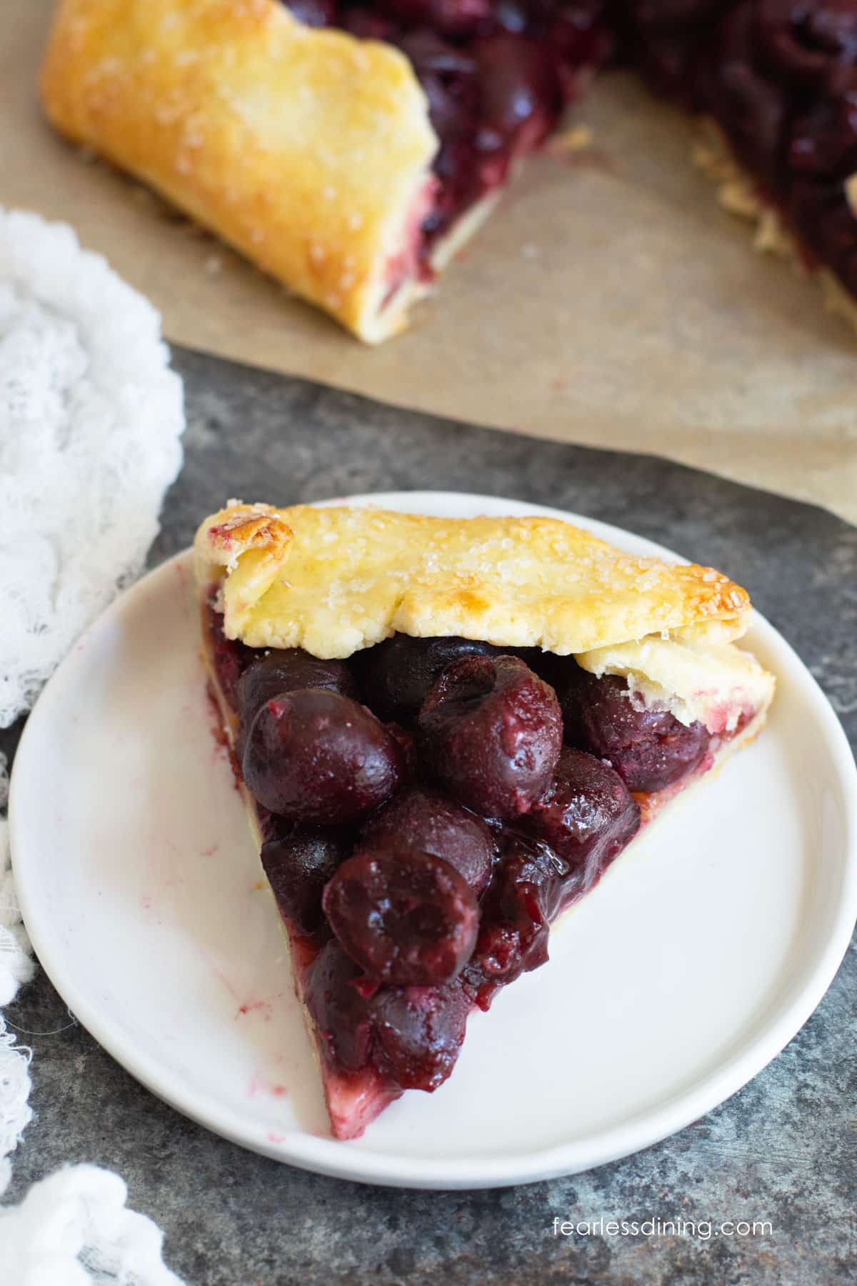 A slice of gluten free cherry galette on a white plate.