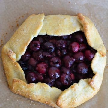 A baked gluten free cherry galette on a baking tray.