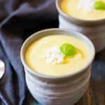 Two small bowls of chilled pineapple soup.