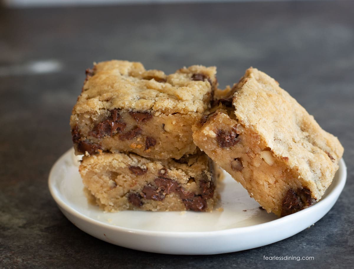 Three gluten free blondies on a plate. Two are stacked and the third is next to the stack.