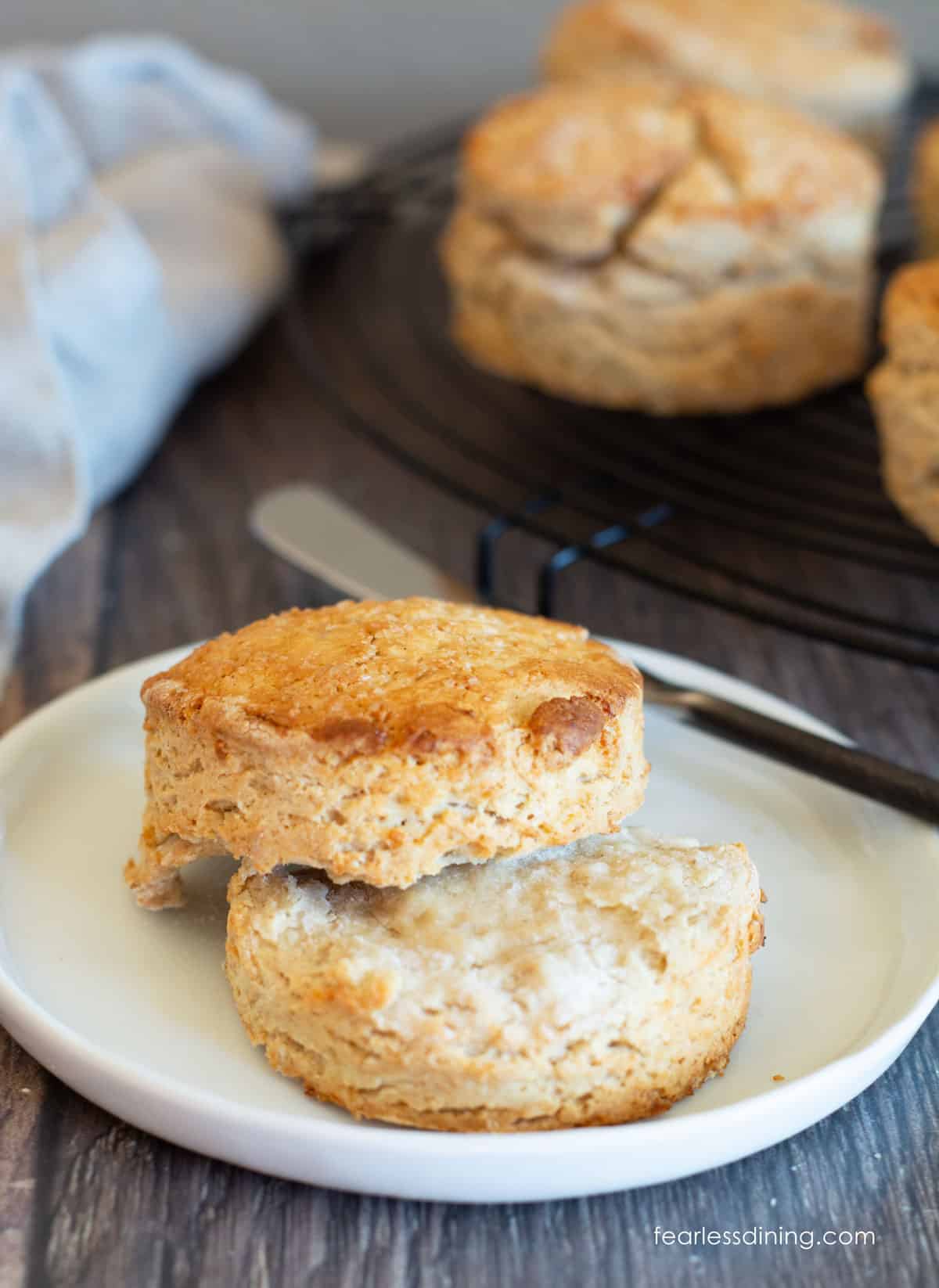 A biscuit cut in half on a small white plate.